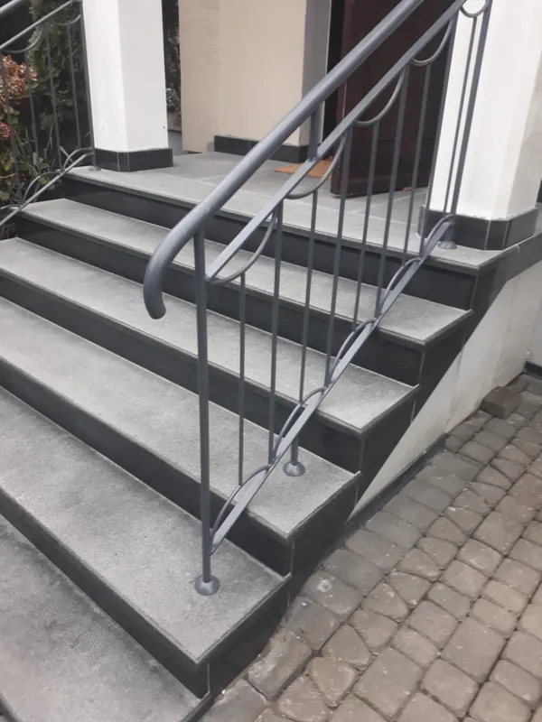 Szare schody granitowe z metalową balustradą przy wejściu