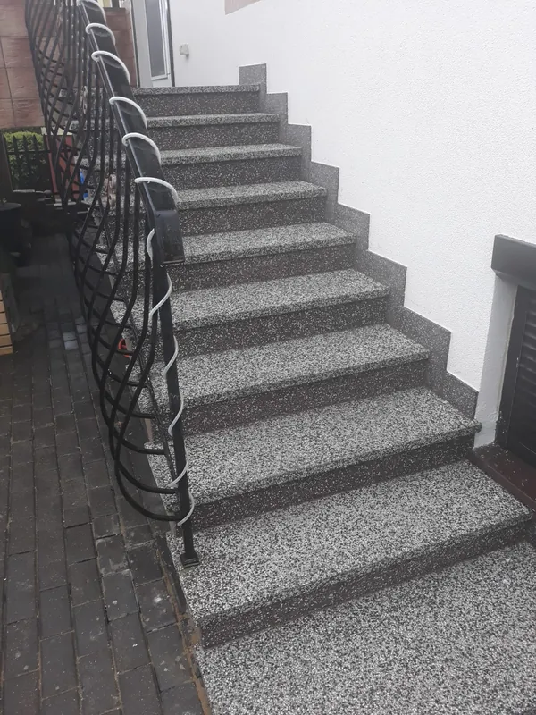 Schody z lastryka płukanego z ciemną balustradą